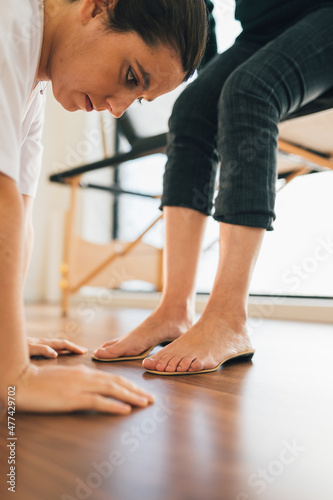 Chiropodist checking the custom foot insole of a patient on the floor in the medical center