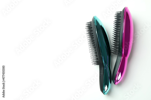 Colored plastic hair brushes on white background