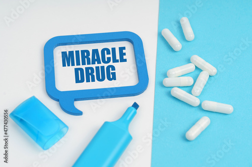 On the white and blue surface are a marker, tablets and a plate inside which the inscription - MIRACLE DRUG