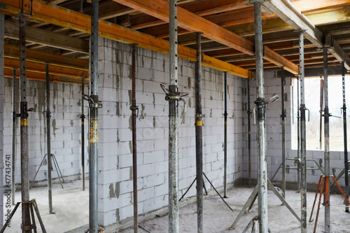 The supports of monolithic floor formwork at a construction site. Telescopic props for concrete flooring. Construction of a modern apartment building 