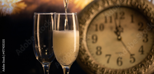 champagne glasses, clock at midnight and fireworks  New Year