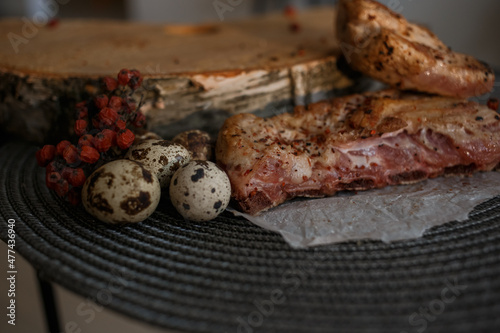 A delicious piece of meat cooked on the grill lies on a wooden board with berries