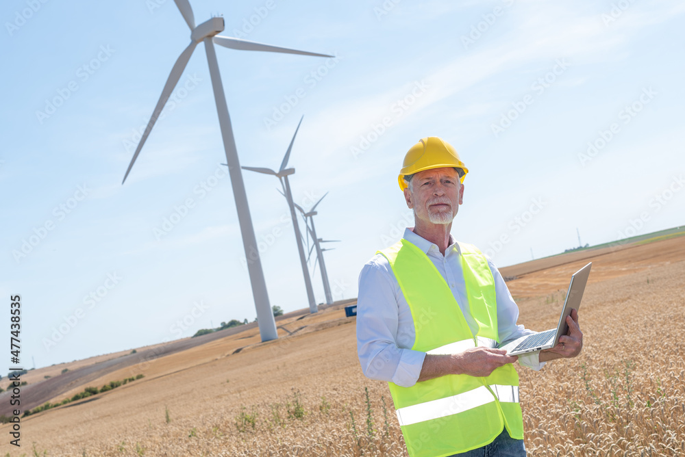 Portrait of engineer using laptop for wind turbine inspection Portrait of engineer using laptop for wind turbine inspection