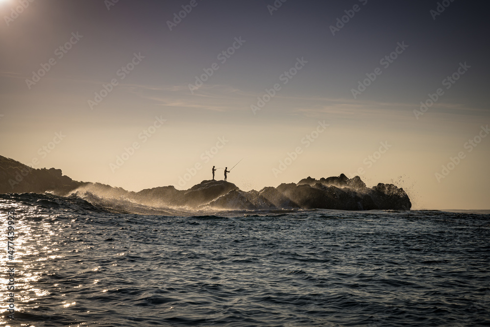 Fishermen, waves and lighthouse