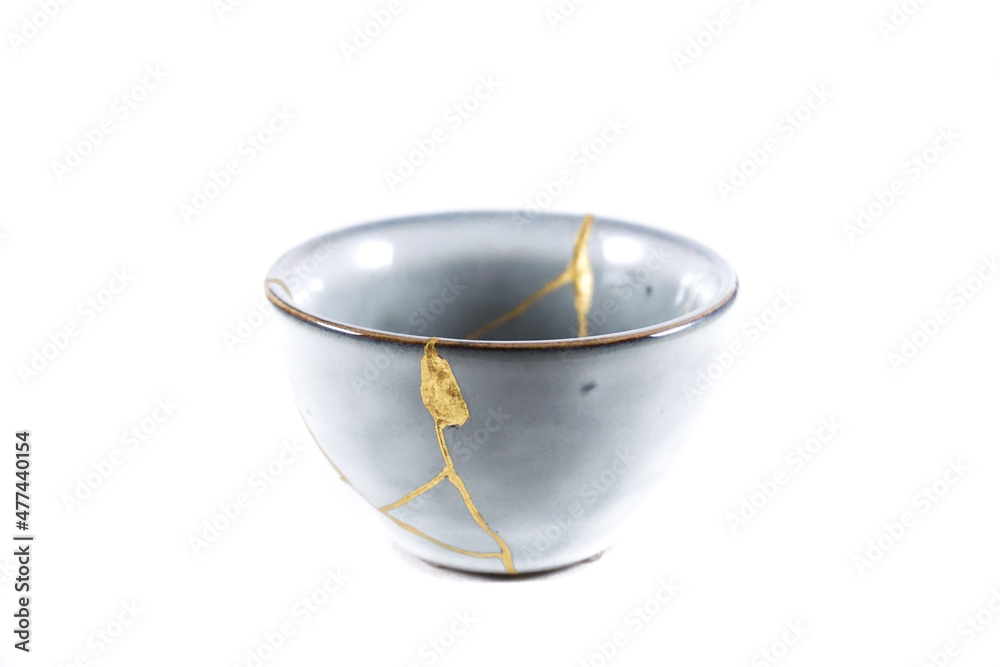 Isolated Japanese kintsugi bowl, antique pottery restored with gold