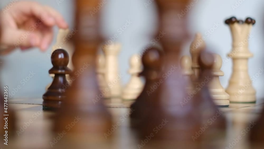 chessboard rotates in a circle. slow motion video. children's hand puts a chess piece on the chess table. Business Solutions, Success Strategy. chessboard rotates in a circle. slow motion video. children's hand puts a chess piece on the chess table. Business Solutions, Success Strategy.