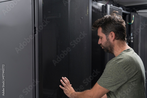  Technicians team updating hardware inspecting system performance in super computer server room or cryptocurrency mining farm.