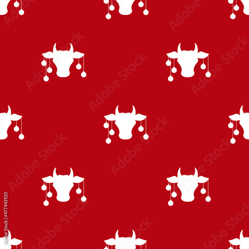 Seamless pattern. Cow head with red christmas tree toy balls on horns, snow and stars.