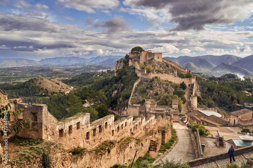 The medieval castle of Xativa against a dramatic and bright sky after the rain. District of Valencia. Spain