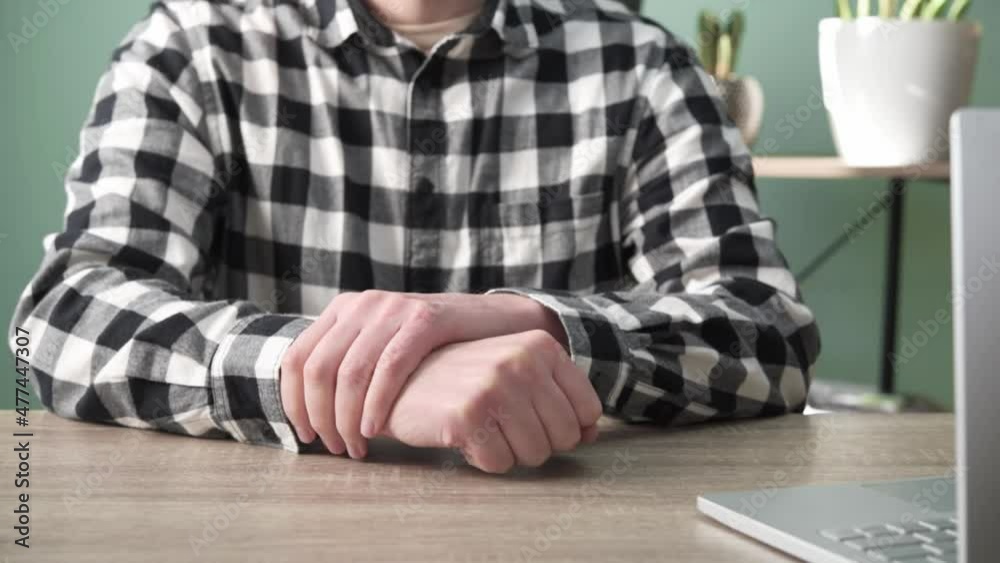 A man suffering from joint pain in his hand and wrist, rheumatoid arthritis and occupational disease A man suffering from joint pain in his hand and wrist, rheumatoid arthritis and occupational disease