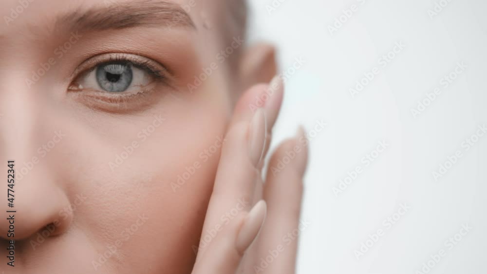 Young woman applying face cream at her face. Beauty model with perfect fresh skin and long eyelashes cares about her skin at home. Spa and Wellness, Skin Care Concept. Close up. Cosmetics concept.