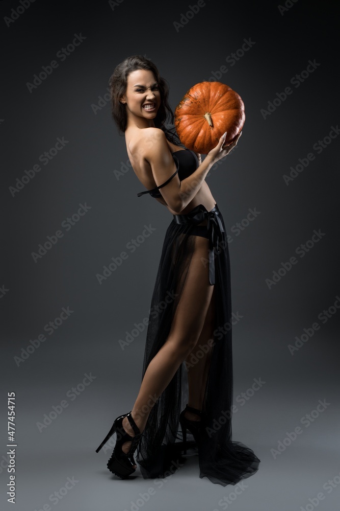 Crazy woman in underwear with pumpkin in studio Crazy woman in underwear with pumpkin in studio