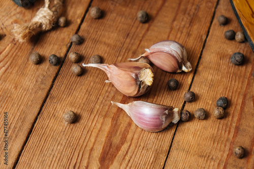 Garlic, garlic clove, allspice on vintage wooden background. Space for text, copy space. The concept of healthy eating.