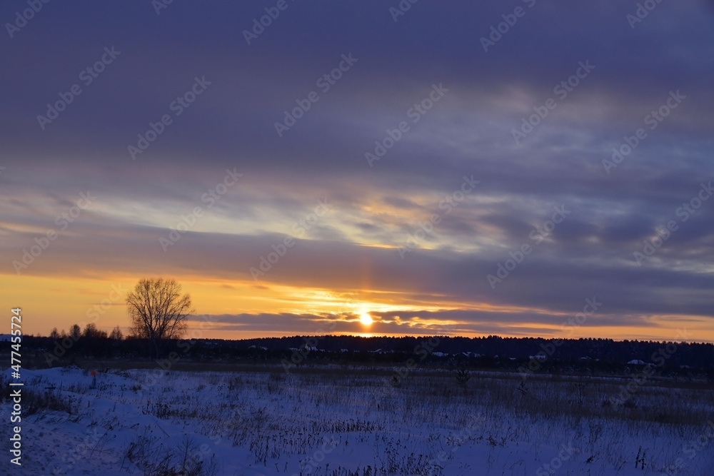 Winter sunset in the village over the forest Winter sunset in the village over the forest