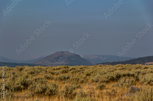 Landscape in Yellowstone National Park on a sunny day smoke from wildfires visible in the background