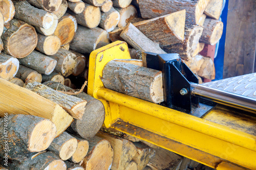 A man working with the firewood to split the logs by the machine