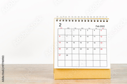 February 2022 desk calendar on wooden background.