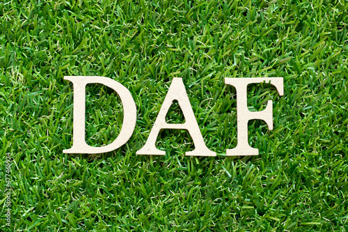 Alphabet letter in word DAF (Abbreviation of Delivered at frontier) on green grass background