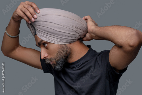 Fotografie, Obraz Calm concentrated male straightening the turban on his head