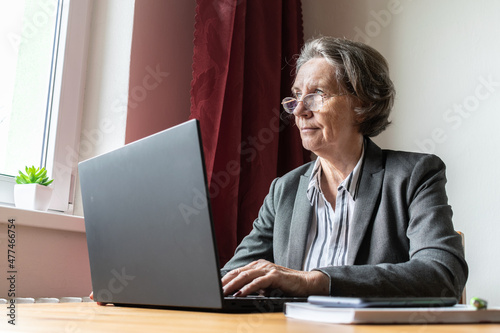 senior old woman female sit desk, home office online notebook laptop work business distance freelancer