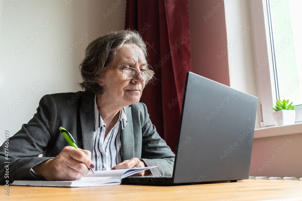 senior old woman female sit desk, home office online notebook laptop work distance freelancer write pen, take notes senior old woman female sit desk, home office online notebook laptop work distance freelancer write pen, take notes