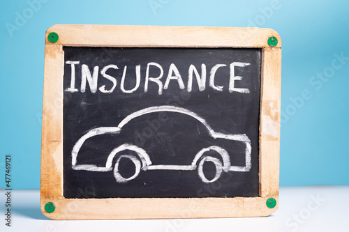 concept of car or vehical insurence showing by placing vehicle insurence sign board on blue background photo