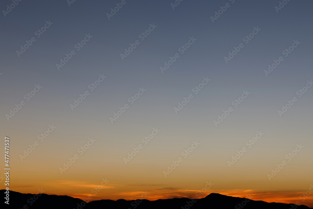 Obraz premium Heaven at early morning with copy space. Sunset, sunrise backdrop.Predawn clear sky with orange horizon and blue atmosphere. Smooth orange blue gradient of dawn sky.