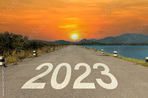 2023 written on highway road in the middle of empty asphalt road and beautiful sunset sky. New year 2023. Concept of planning and challenge, business strategy