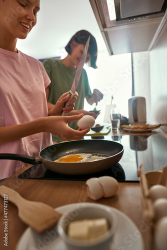 Fototapeta Naklejka Na Ścianę i Meble -  Young girls cooking breakfast at home kitchen