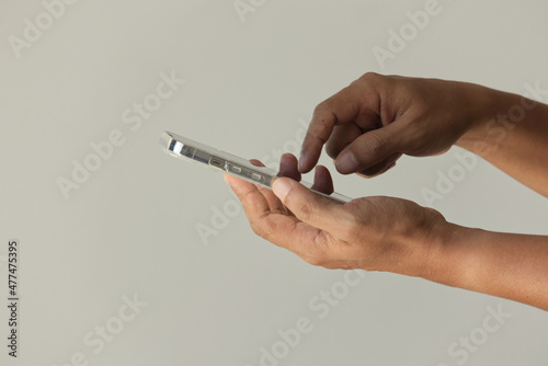 man entrepreneur using a mobile in the him hand calculating financial expenses at home office, black digital calculator on white background, top view.
