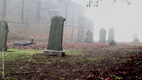 Panning Across Gravestones And A Church On A Foggy Winter's Day 