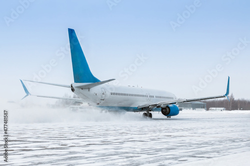 Taxiing of a passenger aircraft on the airport apron in a snow blizzard
