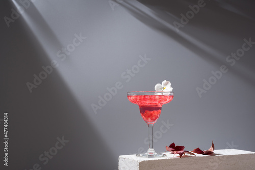 Glass of pomegranate margarita with flower blooms photo