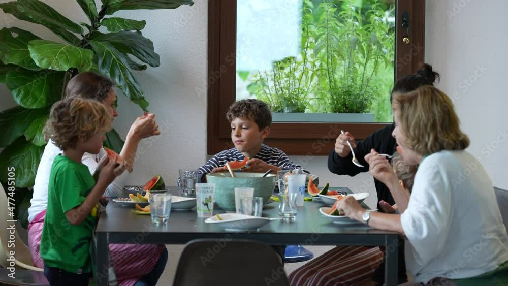 Family gathered at table eating food, real life family sitting at lunch time Family gathered at table eating food, real life family sitting at lunch time