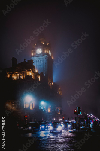 traffic passing a fog-shrouded building at night in edinburgh