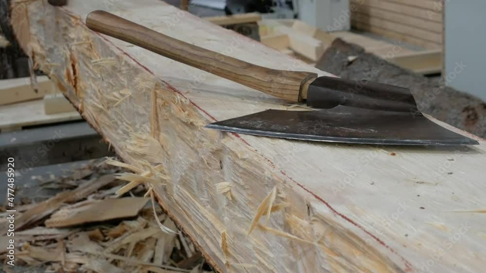 Carpentry workshop. Handmade wooden beam. Work with a carpenter's ax. Carpentry workshop. Handmade wooden beam. Work with a carpenter's ax.