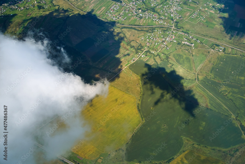 Aerial view from high altitude of earth covered with white puffy cumulus clouds on sunny day