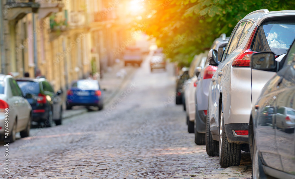 City traffic with cars parked in line on street side City traffic with cars parked in line on street side