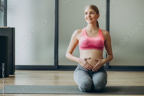 Pregnant woman exercicising on a class of pilates
