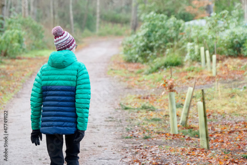 Single elderly woman walking alone in forest during lockdown for good mental and physical health photo