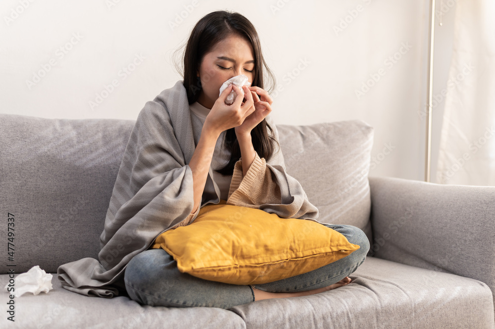 Daily life or health problem concept : Young Asian woman caught a cold and have a running nose or fever have to rest at her home and absent from her job. Daily life or health problem concept : Young Asian woman caught a cold and have a running nose or fever have to rest at her home and absent from her job.