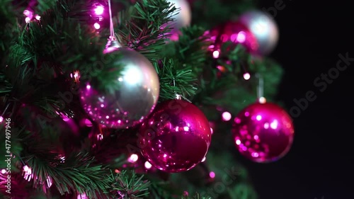 Red and silver Christmas balls swing on the branches of the city Christmas tree. Close-up