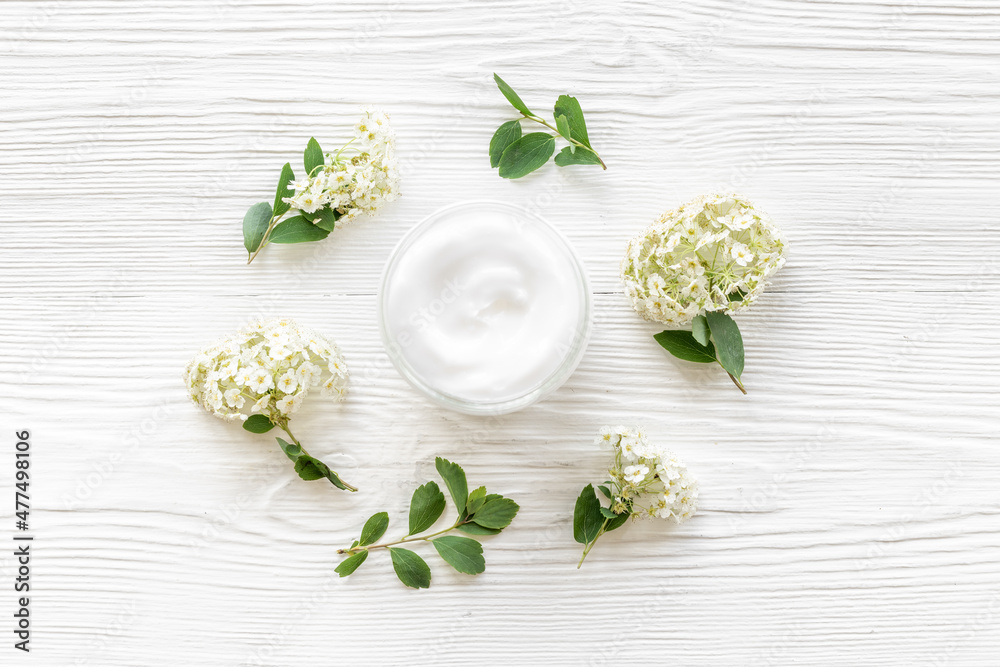 White blossoms flowers with skin cream in glass jar White blossoms flowers with skin cream in glass jar