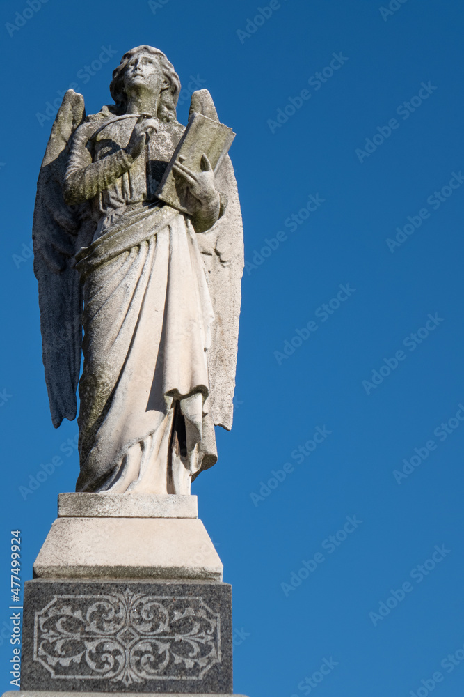 Fototapeta premium Angel status against deep blue sky background.