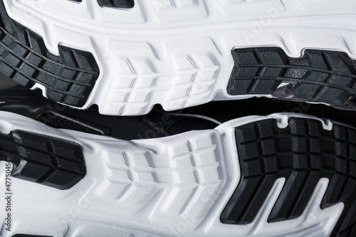 The black and white sole of trendy sports sneakers is a close-up in full screen.