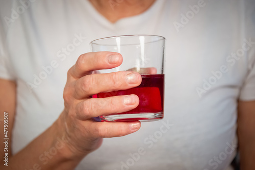 Senior woman (old lady) with a glass of juice. An elderly lady and her hands.