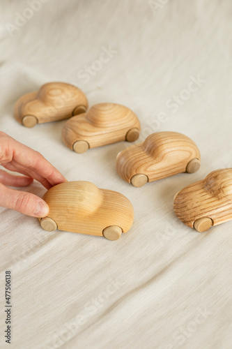 Little wooden eco toy car for child on minimalistic background with hands photo