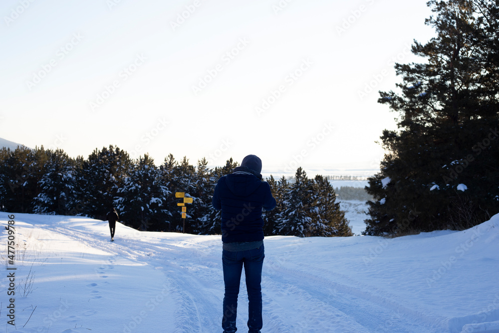 photographer holds his camera and taking pictures of winter landscape