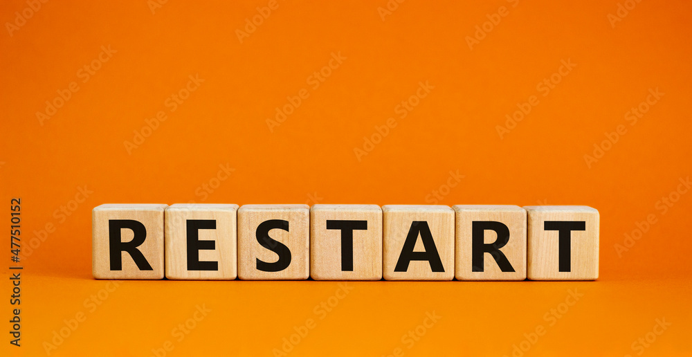 Restart and start symbol. The concept word Restart on wooden cubes. Beautiful orange table, orange background, copy space. Business restart and start concept. - obrazy, fototapety, plakaty 
