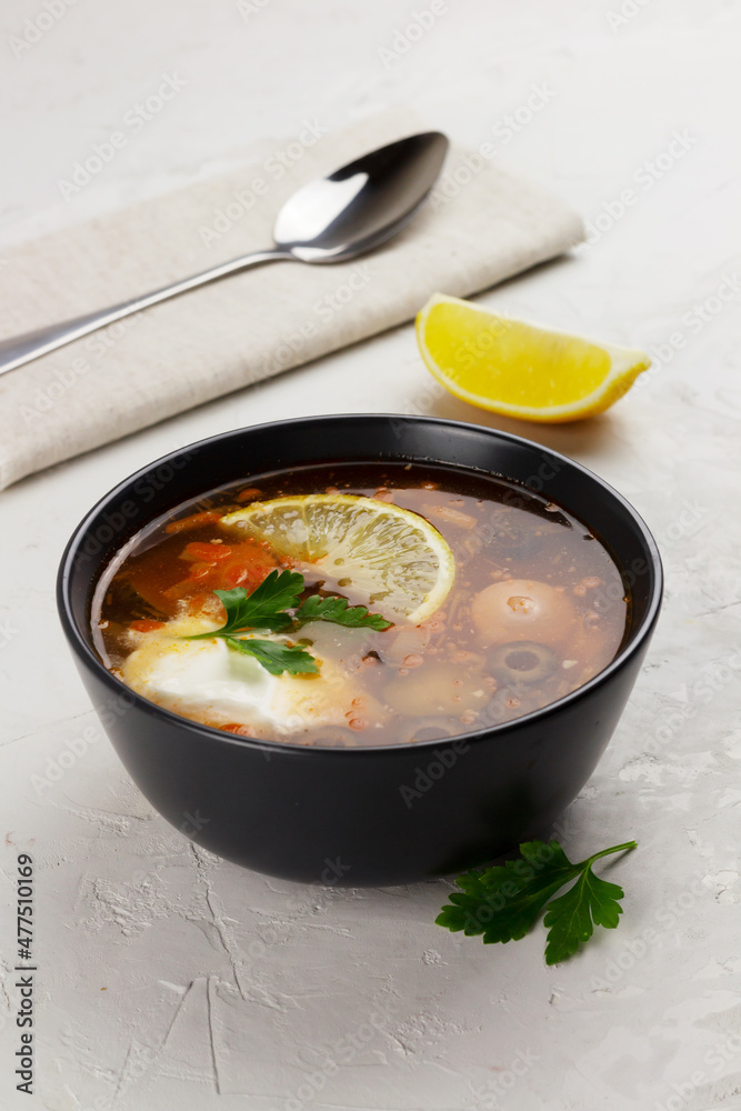 Traditional russian meat soup Solyanka in a bowl